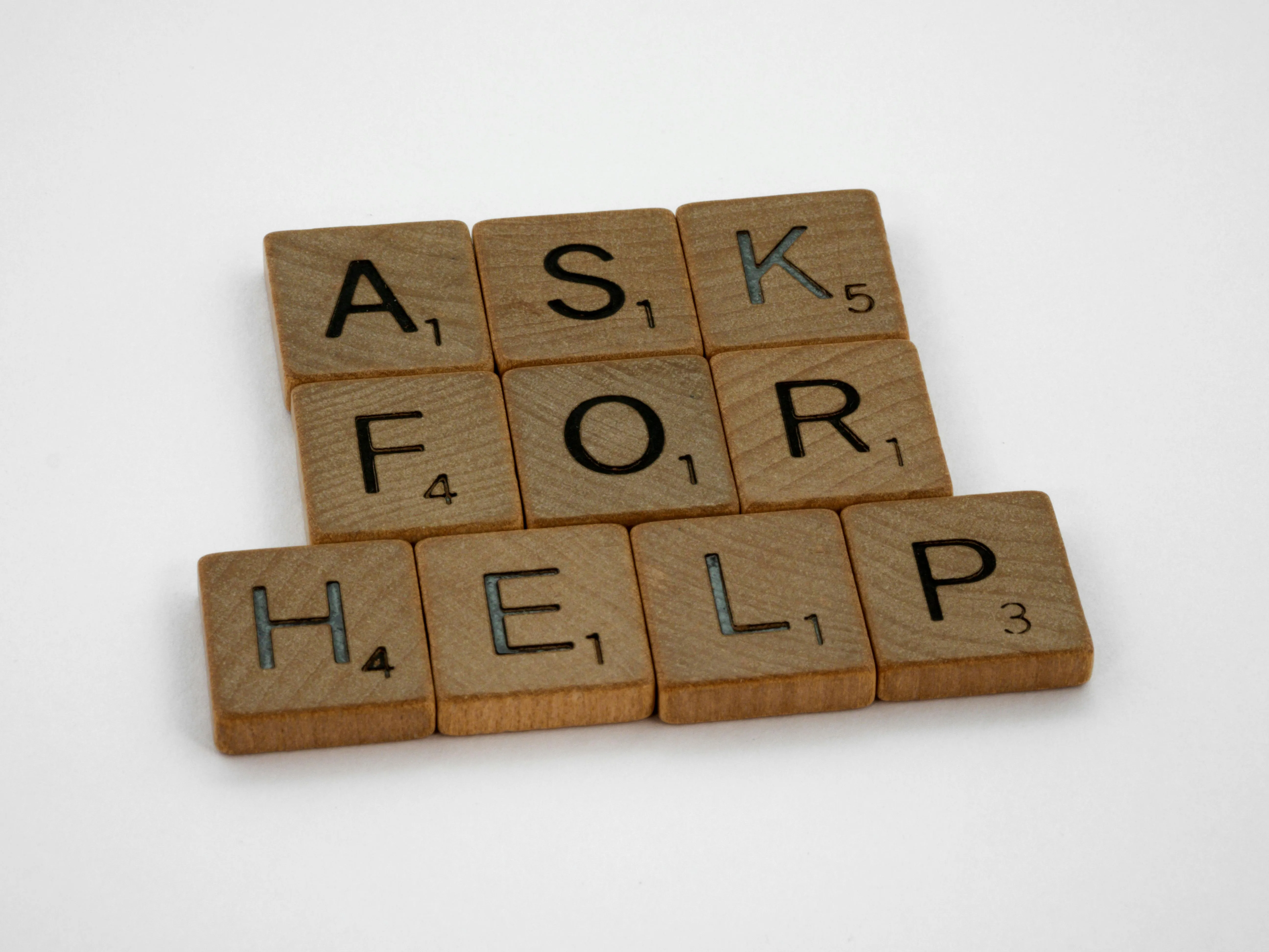 Scrabble letters spelling ask for help